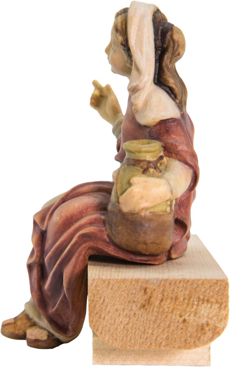 Bergère avec une cruche d'eau assise sur un tronc d'arbre