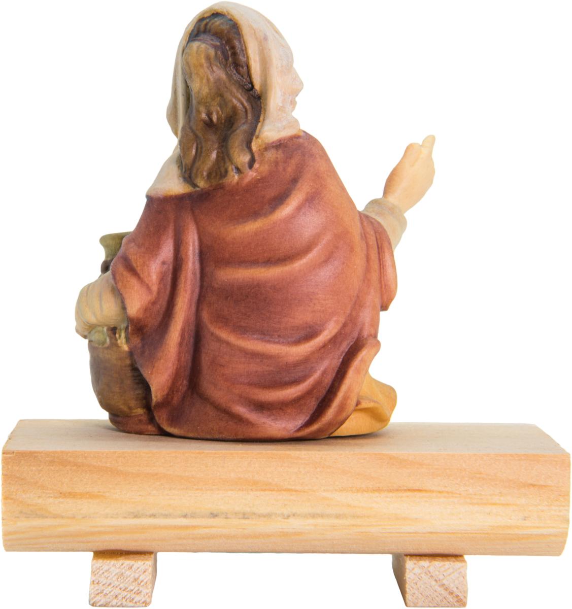 Bergère avec une cruche d'eau assise sur un tronc d'arbre